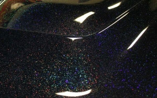 Black holographic metal flake on a car hood. Holographic Flake.