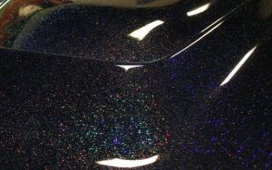 Black holographic metal Flake on a car hood. Holographic Flake.